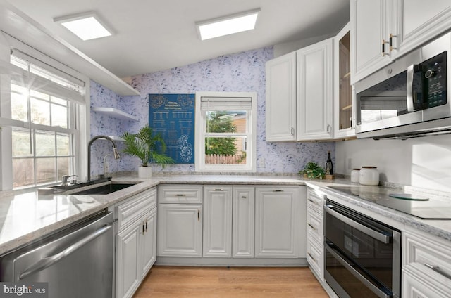 kitchen featuring a wealth of natural light, white cabinetry, appliances with stainless steel finishes, and sink