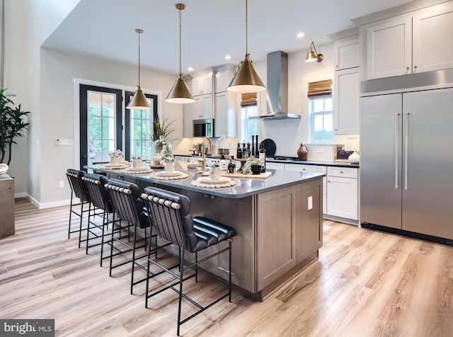 0707007728 Hook Rd Nottingham, Unit Nottingham, Westminster, MD 21157 - kitchen featuring stainless steel appliances, wall chimney range hood, light wood-style flooring, dark countertops, and recessed lighting