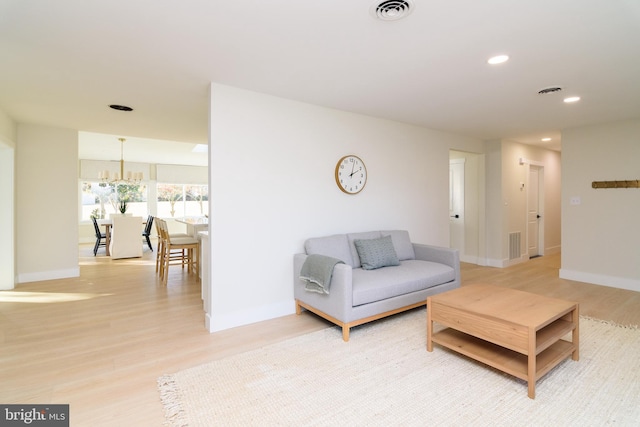 living room with a chandelier and light hardwood / wood-style floors