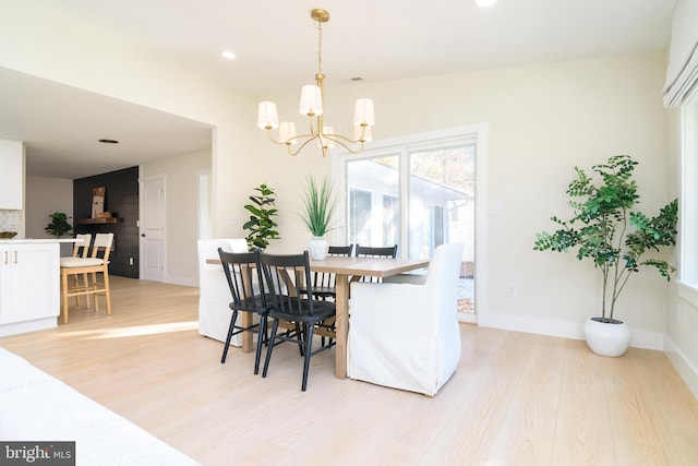 dining area with a chandelier and light hardwood / wood-style floors