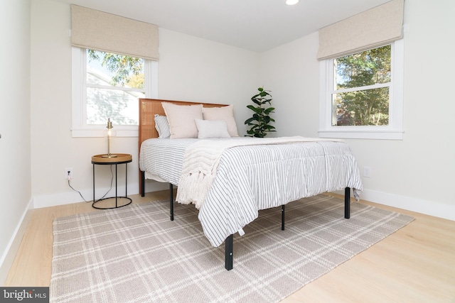 bedroom with wood-type flooring and multiple windows