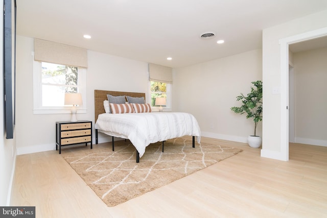 bedroom featuring multiple windows and hardwood / wood-style floors