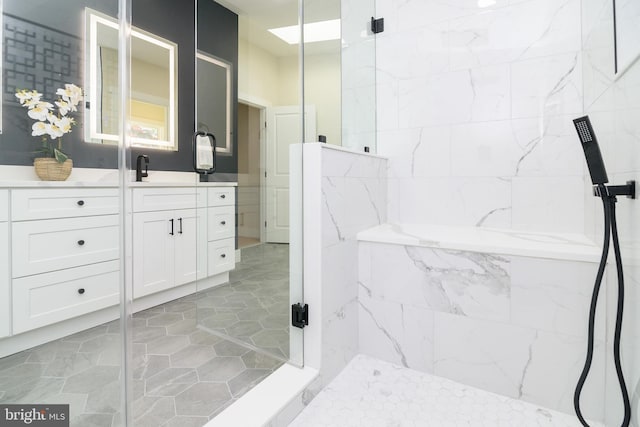 bathroom with a shower with shower door and vanity