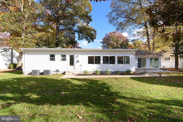 ranch-style home with central air condition unit and a front yard