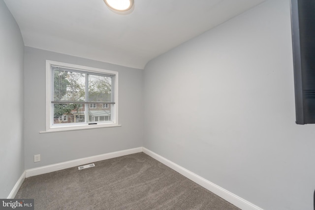 unfurnished room with carpet flooring and lofted ceiling