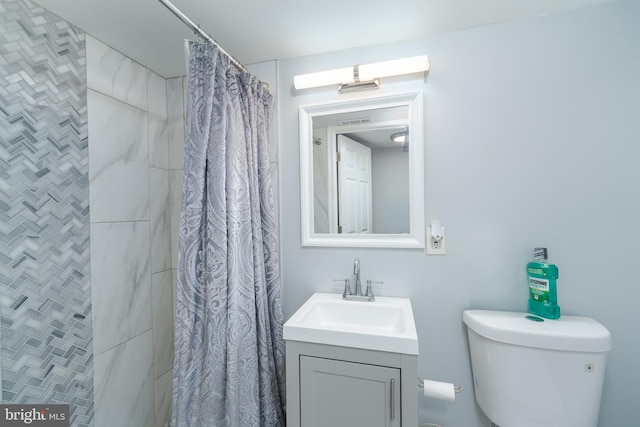 bathroom featuring toilet, vanity, and a shower with shower curtain