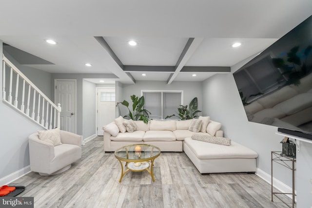 living room featuring beamed ceiling and light hardwood / wood-style flooring