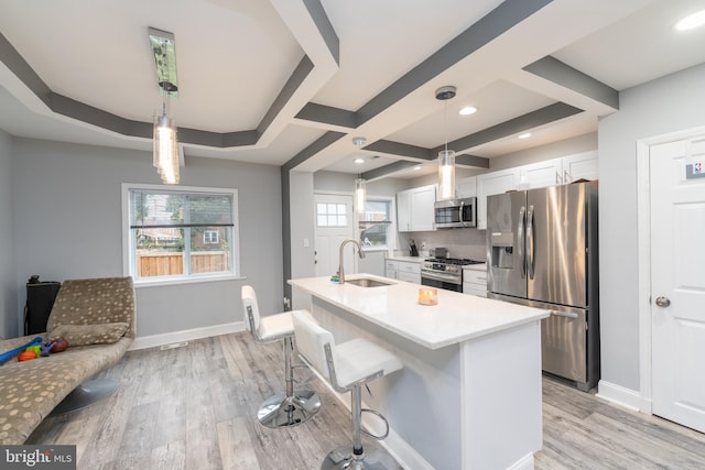 kitchen with a wealth of natural light, sink, white cabinets, and appliances with stainless steel finishes