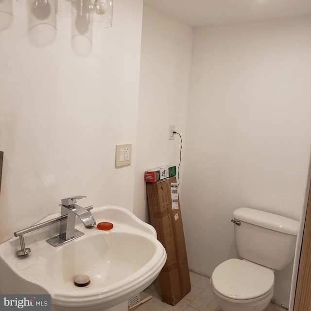 bathroom featuring toilet, tile patterned flooring, and sink