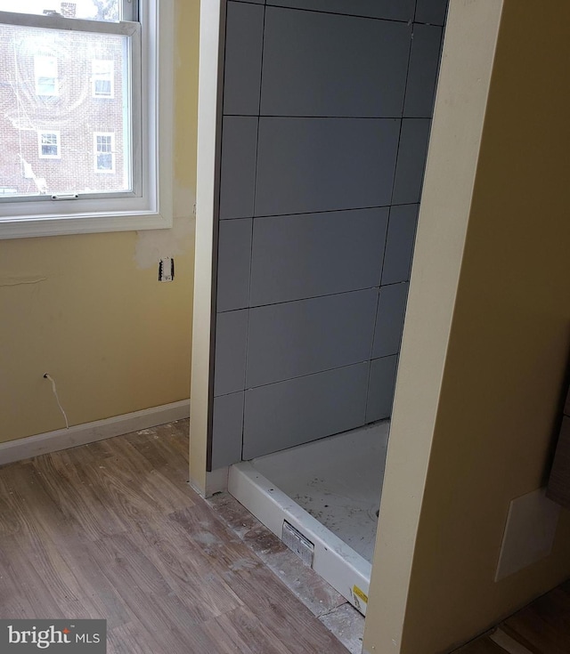 bathroom with a shower and hardwood / wood-style floors