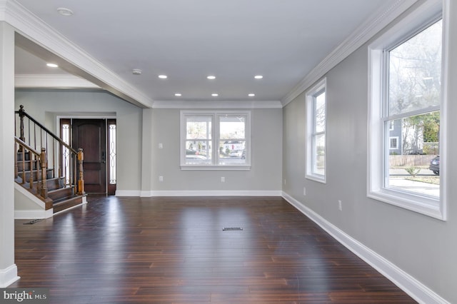 interior space with dark wood-type flooring, ornamental molding, and a healthy amount of sunlight