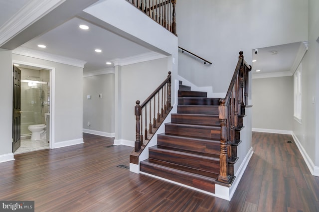 stairs with wood-type flooring and crown molding