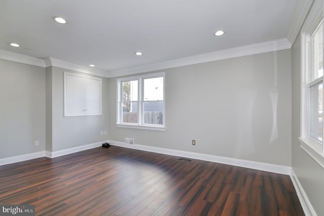 spare room featuring dark wood-type flooring and ornamental molding