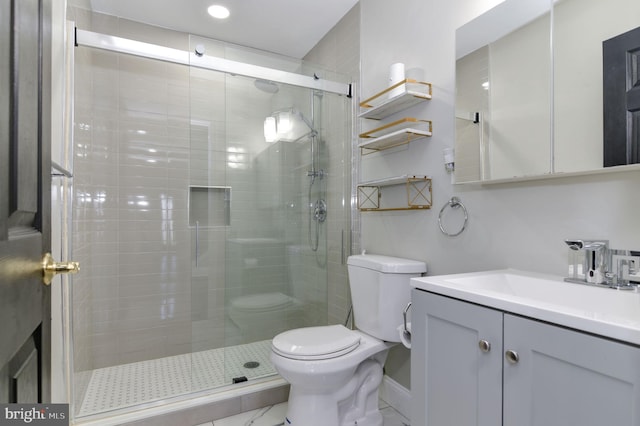 bathroom featuring toilet, vanity, and an enclosed shower