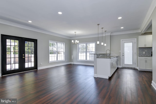 kitchen featuring dark hardwood / wood-style floors, pendant lighting, sink, white cabinets, and dark stone countertops