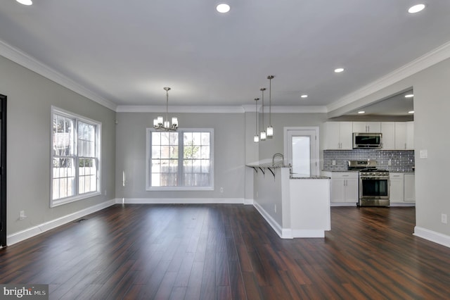 kitchen featuring stainless steel appliances, dark hardwood / wood-style floors, white cabinetry, and kitchen peninsula