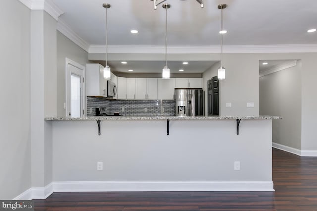 kitchen featuring white cabinets, kitchen peninsula, stainless steel appliances, and hanging light fixtures