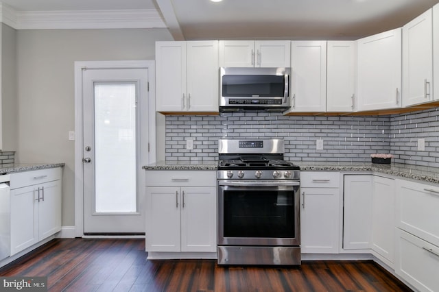 kitchen with tasteful backsplash, crown molding, white cabinetry, appliances with stainless steel finishes, and dark hardwood / wood-style flooring