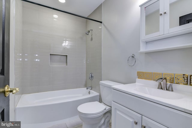 full bathroom with tile patterned flooring, tiled shower / bath, toilet, and vanity