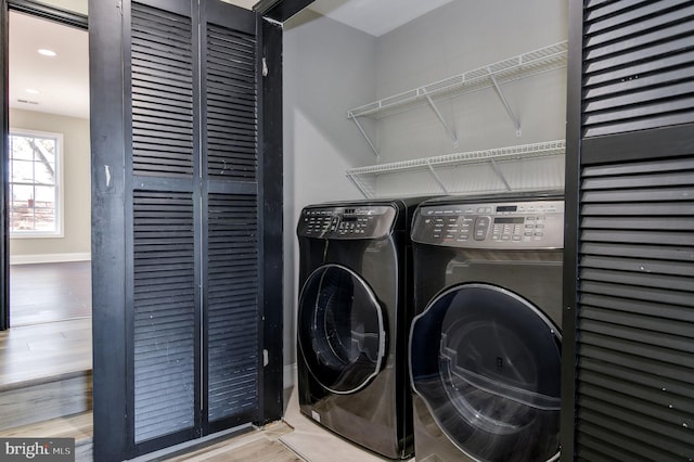 laundry area with wood-type flooring and washing machine and dryer