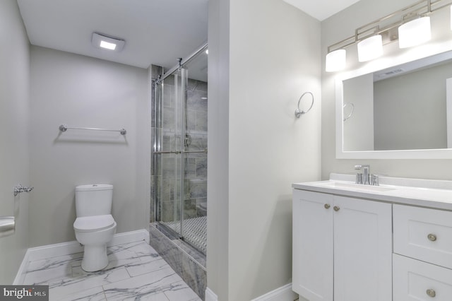 bathroom featuring toilet, vanity, and a shower with shower door