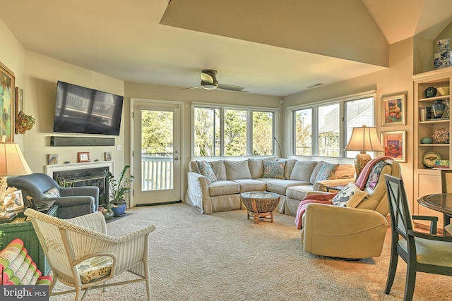 living room with carpet floors, ceiling fan, and vaulted ceiling