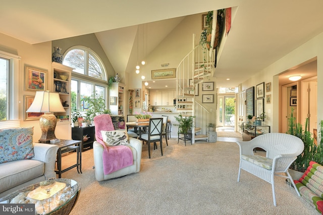 living room with light carpet and high vaulted ceiling