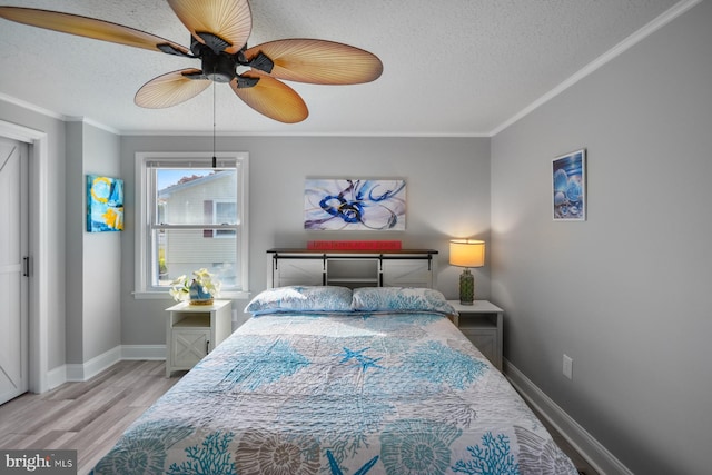 bedroom with crown molding, ceiling fan, light hardwood / wood-style floors, and a textured ceiling