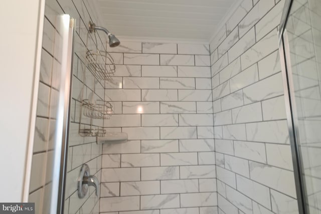 bathroom with tiled shower and ornamental molding