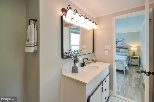 bathroom featuring hardwood / wood-style flooring, crown molding, and vanity