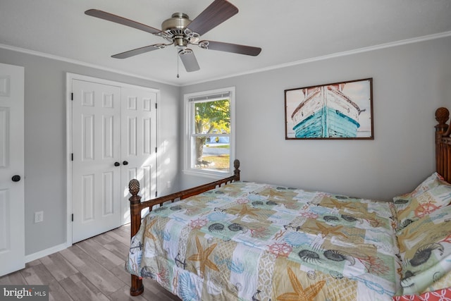 bedroom with ceiling fan, ornamental molding, light hardwood / wood-style floors, and a closet