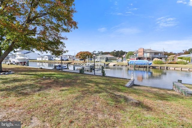 dock area with a water view and a lawn