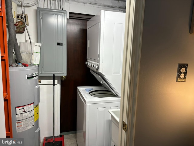 clothes washing area featuring electric panel, stacked washing maching and dryer, and water heater