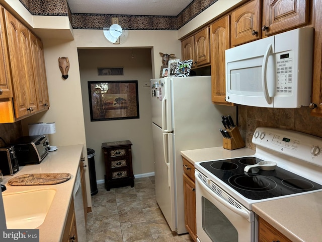 kitchen with sink, white appliances, and a textured ceiling