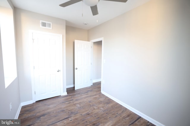 unfurnished bedroom featuring dark hardwood / wood-style floors and ceiling fan