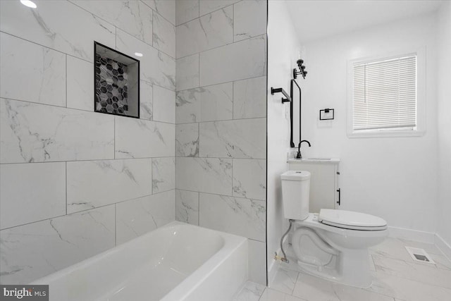 bathroom with tiled shower / bath and toilet