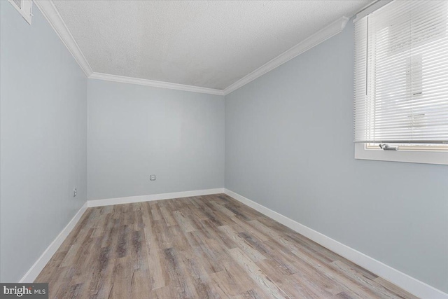 unfurnished room with light hardwood / wood-style floors, a textured ceiling, and crown molding