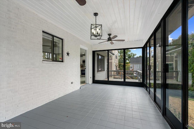 unfurnished sunroom with wooden ceiling, a wealth of natural light, and ceiling fan with notable chandelier