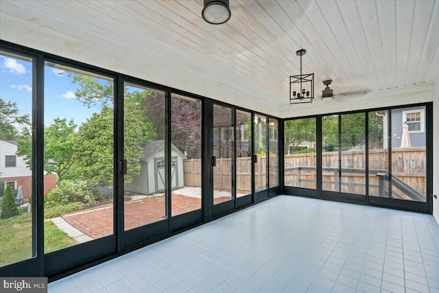 unfurnished sunroom featuring wood ceiling and a notable chandelier