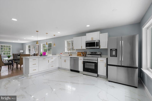 kitchen with white cabinets, kitchen peninsula, appliances with stainless steel finishes, and plenty of natural light