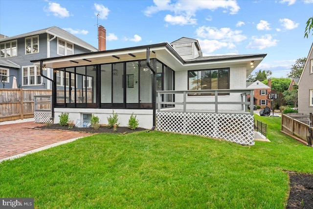 back of property featuring a sunroom and a yard