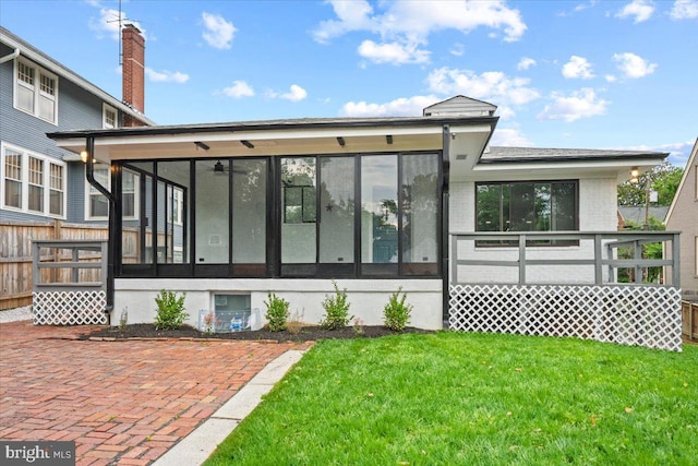 back of house featuring a sunroom and a yard