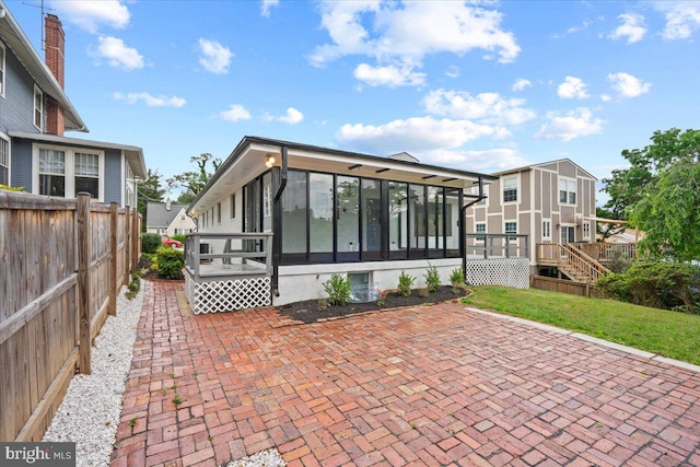 back of house with a yard, a patio area, a sunroom, and a deck