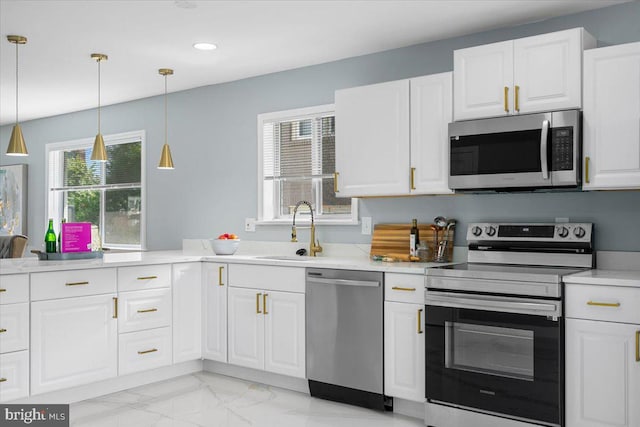 kitchen featuring pendant lighting, white cabinets, sink, and stainless steel appliances