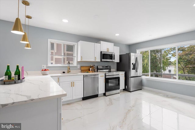 kitchen with white cabinets, sink, pendant lighting, and appliances with stainless steel finishes