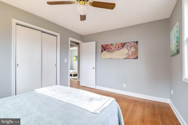 bedroom with a closet, hardwood / wood-style flooring, and ceiling fan