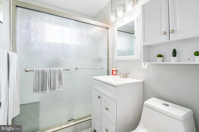 bathroom with a shower with door, vanity, and toilet