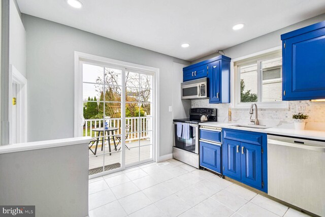 kitchen featuring blue cabinetry, appliances with stainless steel finishes, a healthy amount of sunlight, and sink