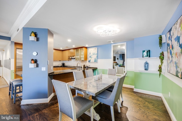 dining area with dark wood-type flooring and ornamental molding