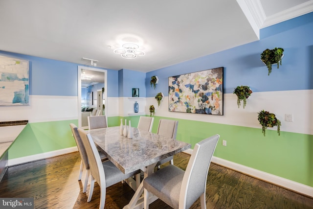 dining room with dark wood-type flooring and crown molding